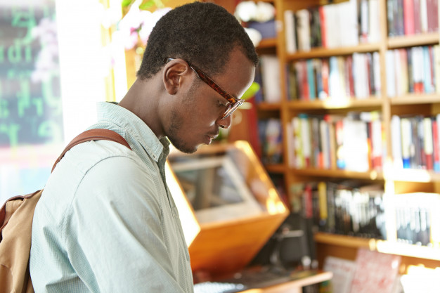 candid-shot-concentrated-black-european-male-student-with-backpack-working-research-college-library-stylish-dark-skinned-man-looking-phrase-book-bookshop-before-vacations-abroad_273609-1019.jpg
